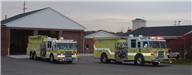 Two Fire Trucks Parked Outside Station