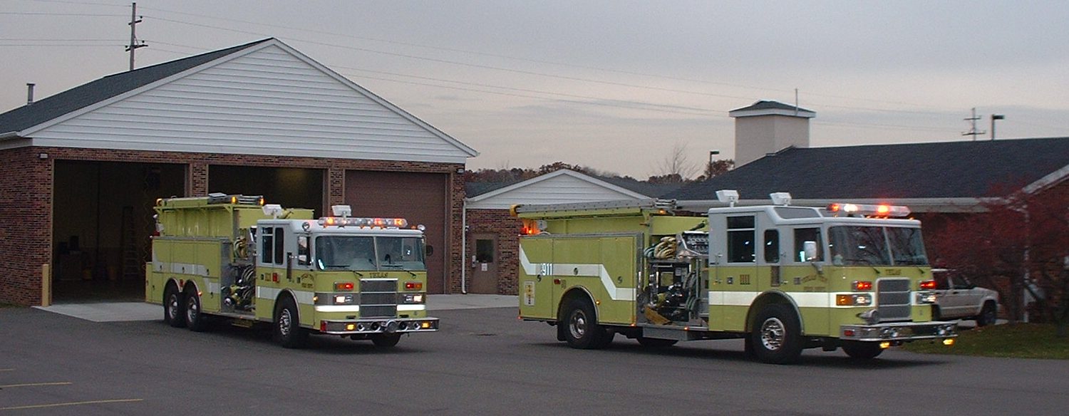 Two Fire Trucks Parked Outside Station